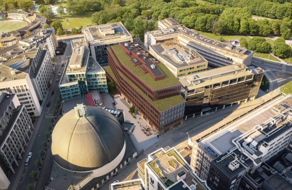 Flyfoto over illustrasjonen av FNV12. Et rødt kontorbygg ved siden av Colosseum kino. Bygningen har grønt tak.