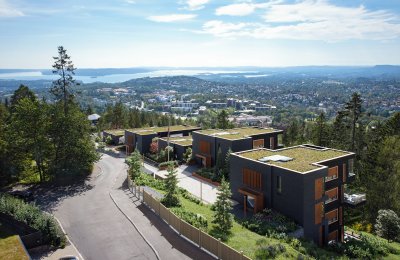 Illustrasjon av leilighetsbygg i grønn omgivelser med utsikt mot Oslo og Oslofjorden